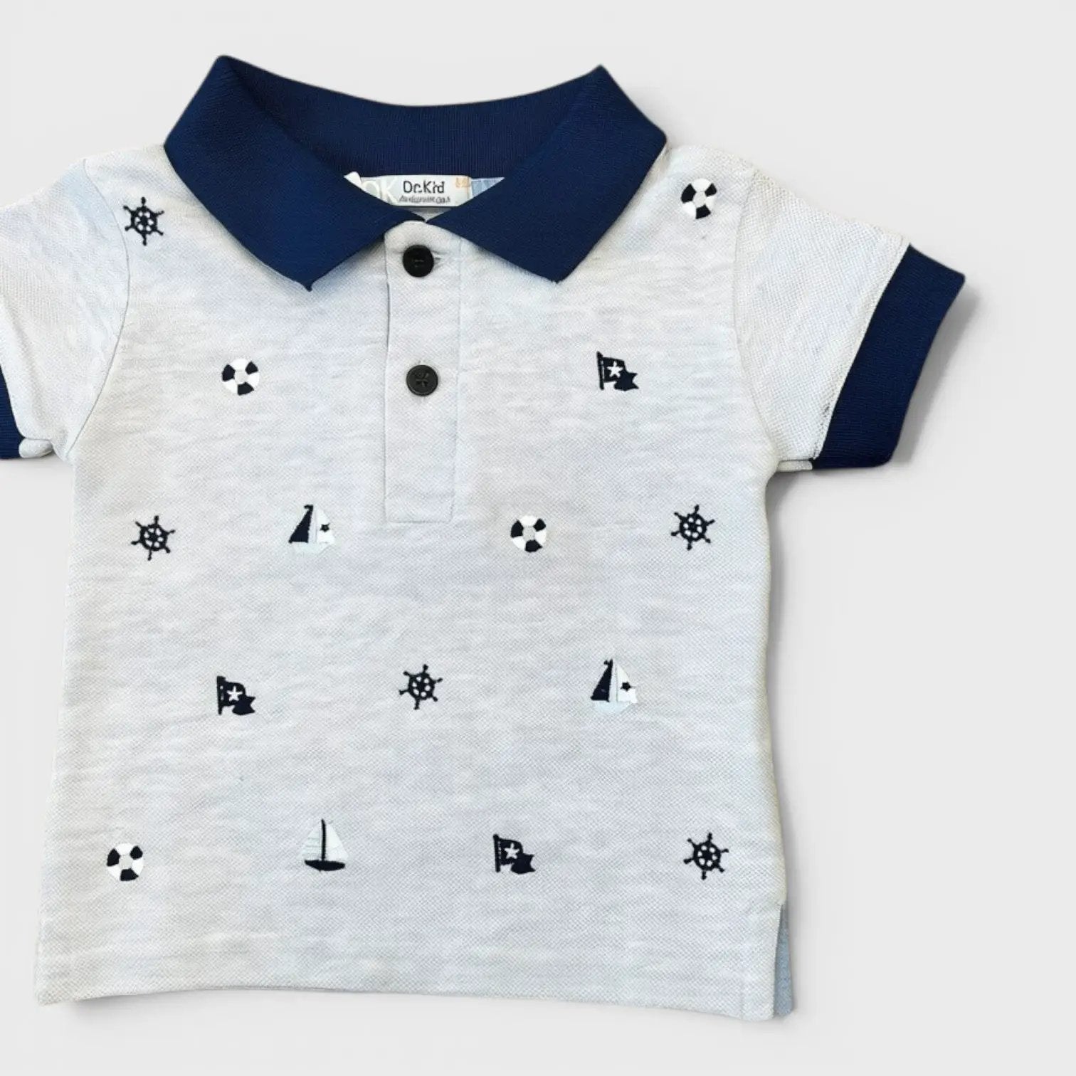 Nanù polo shirt for boys in grey with navy collar and cuffs, featuring a nautical print of sailboats and ship wheels.